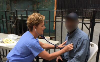 Camille Lloyd, an RN, tends to a patient in New York City.