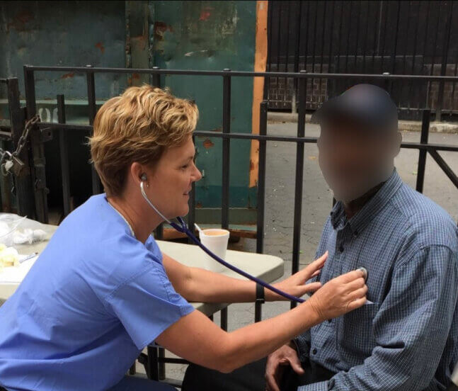 Camille Lloyd, an RN, tends to a patient in New York City.